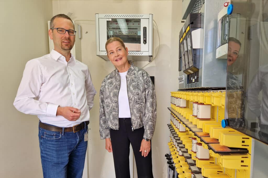 Prof. Florian Steinke von der TU Darmstadt und Ines Schultze (kaufmännische Vorständin e-netz Südhessen) begutachten einen Teil der technischen Ausstattung für das Projekt CyberStress